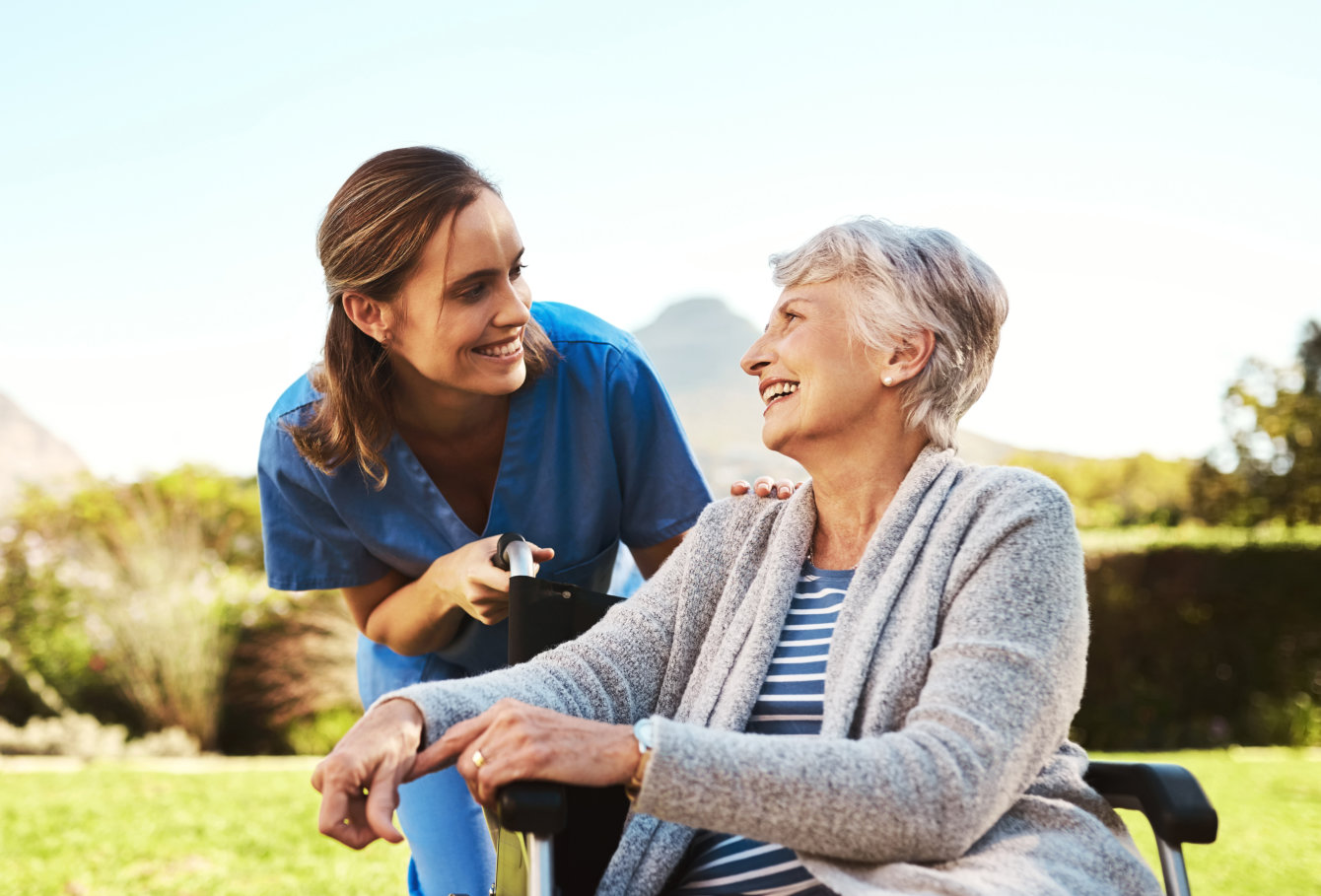 caregiver and elderly woman spending time outside