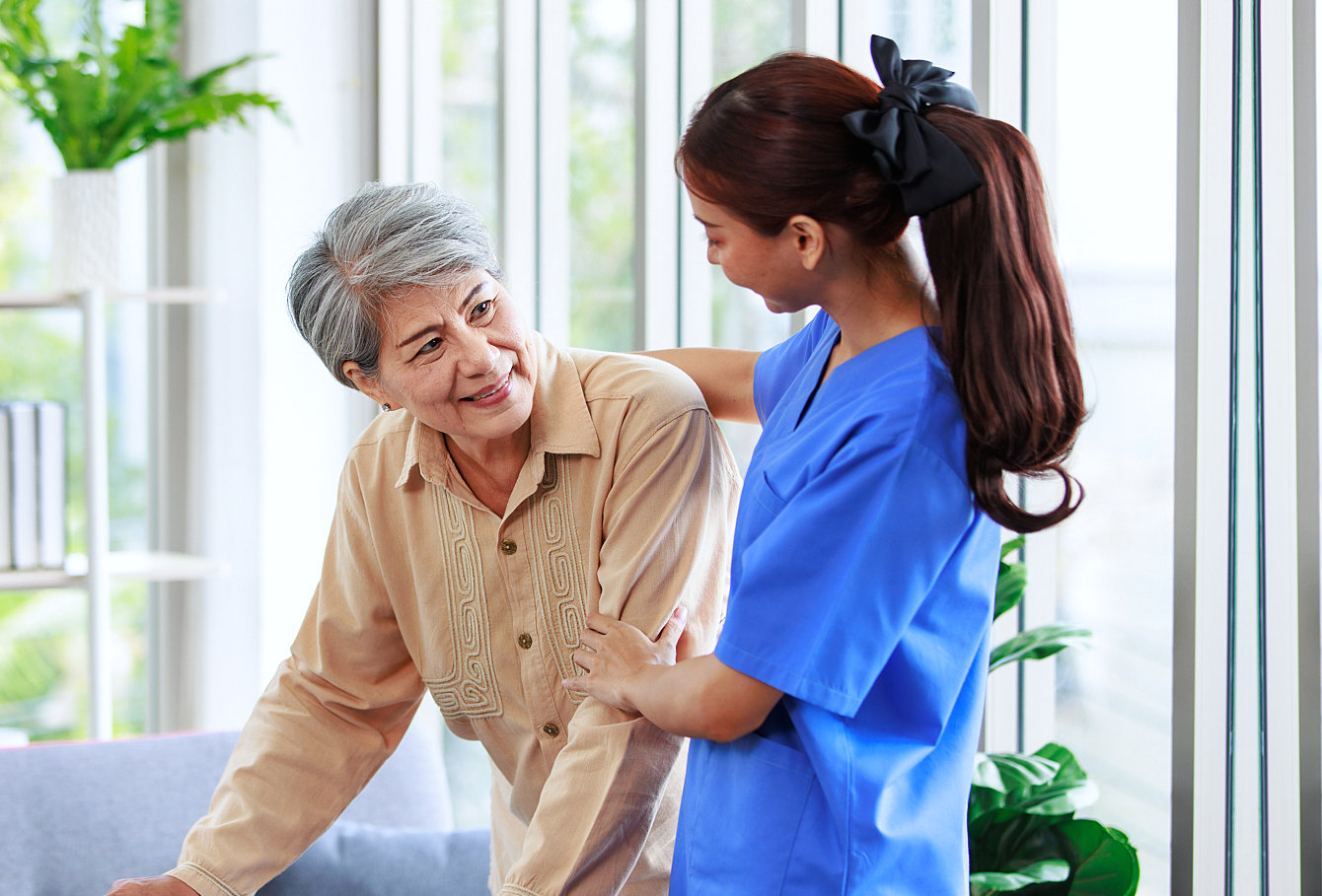 caregiver assisting the elderly woman while walking