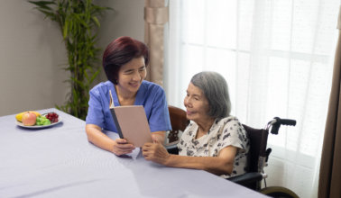 woman is reading aloud a book for dementia therapy with caregiver