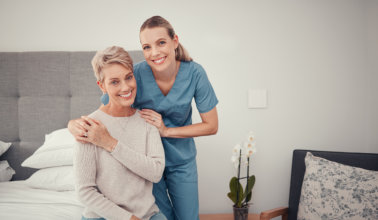 caregiver and elderly woman sitting in the bedroom