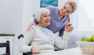 elderly woman holding her caregiver's hand