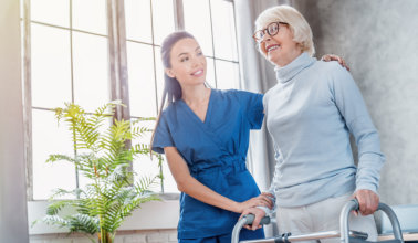 healthcare aide smiling while taking care of the elderly