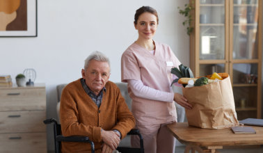 Portrait of man in wheelchair posing with female caregiver