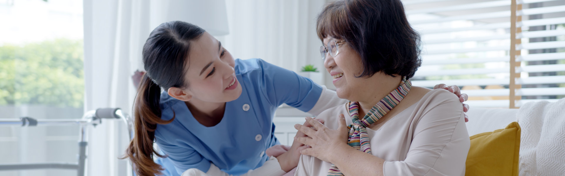 caregiver smiling while looking at the elderly woman