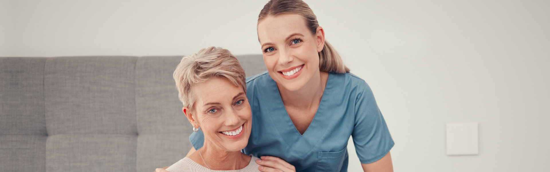 caregiver and elderly woman sitting in the bedroom