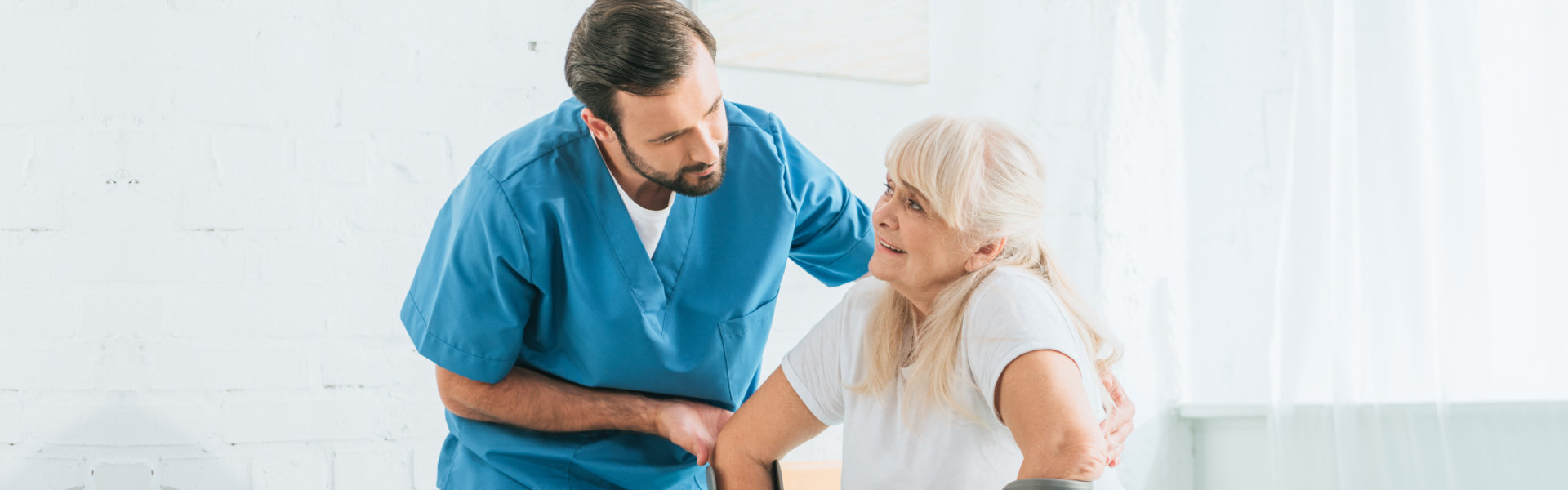 caregiver helping the elderly woman stand up