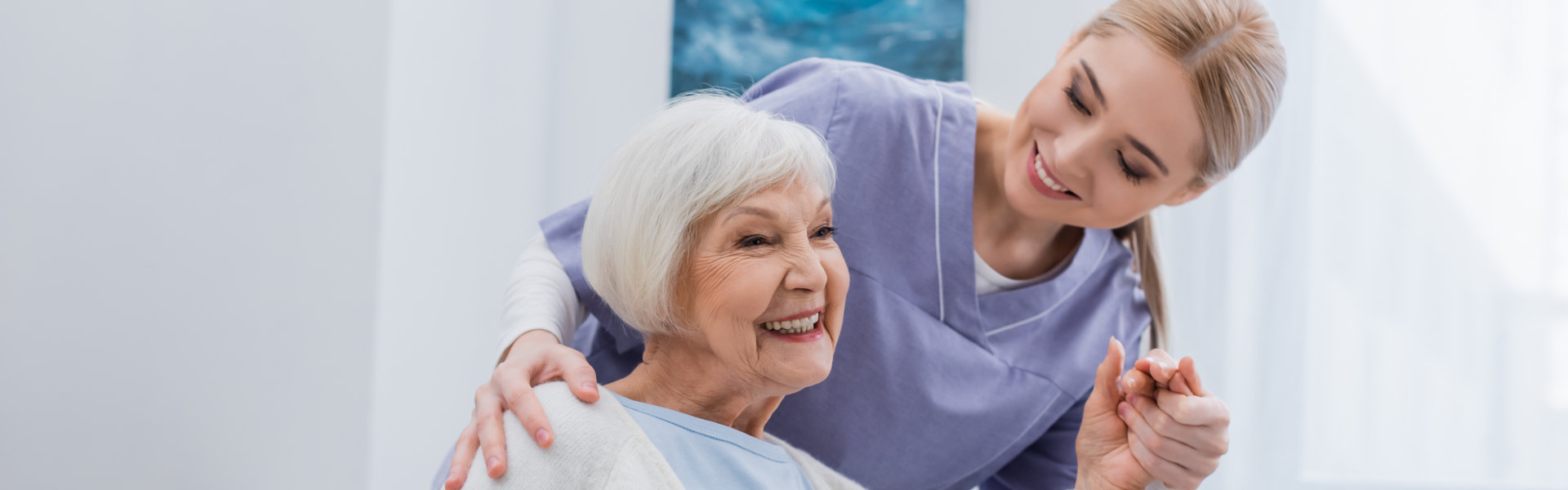 elderly woman holding her caregiver's hand