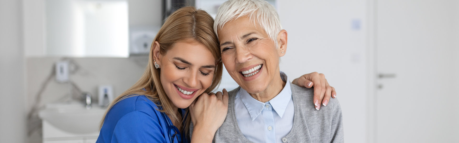 healthcare aide hugging the elderly woman