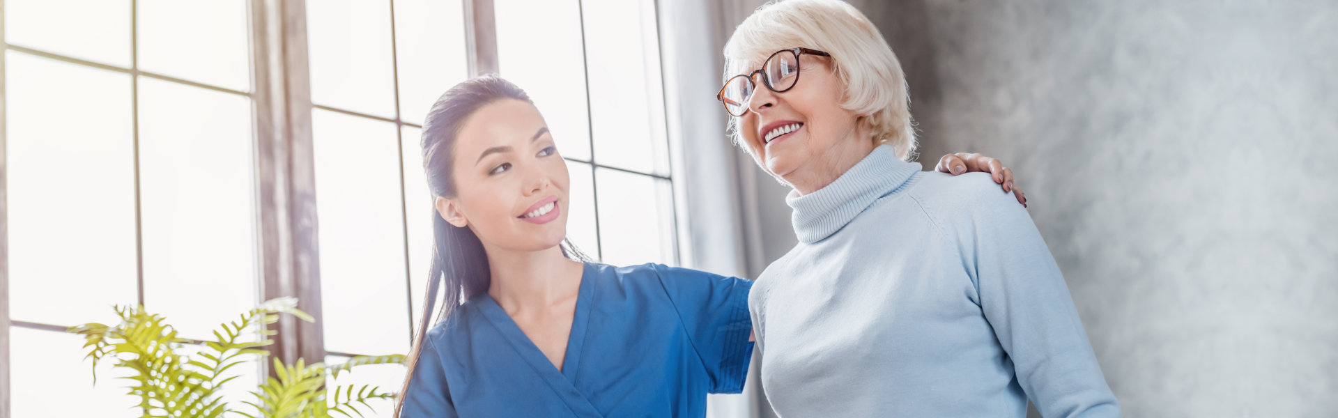 healthcare aide smiling while taking care of the elderly