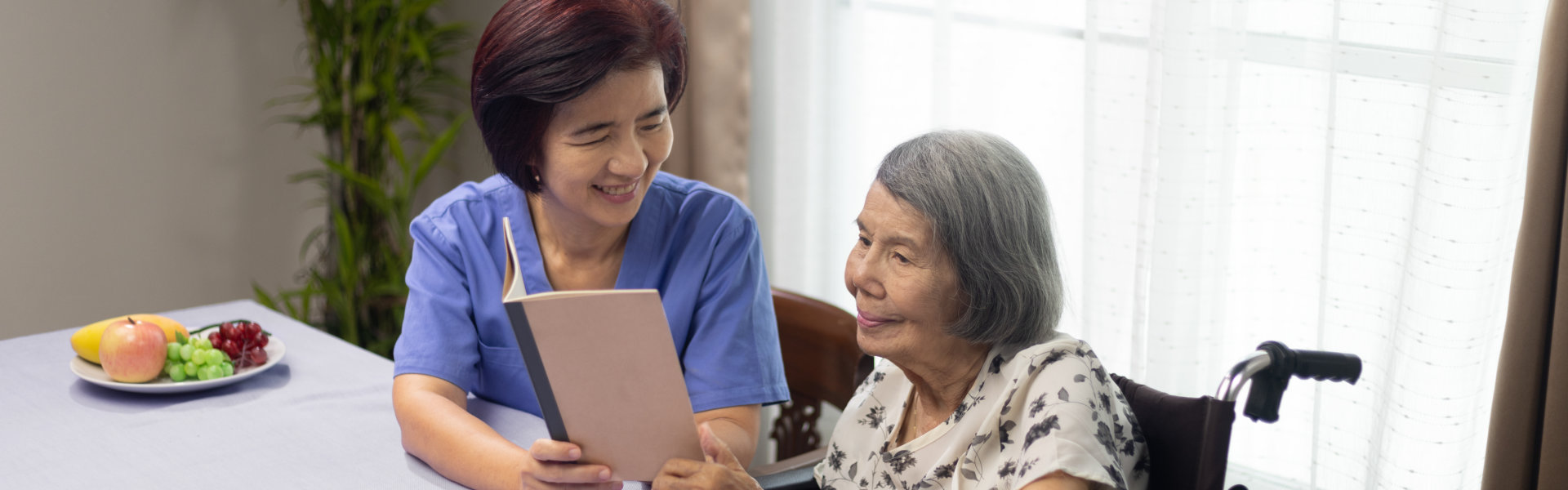 woman is reading aloud a book for dementia therapy with caregiver