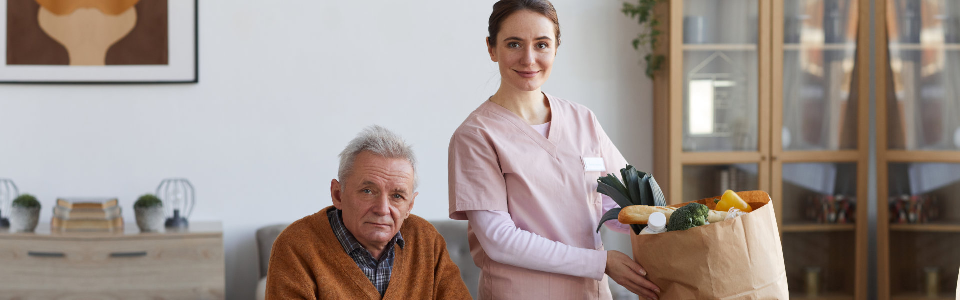 Portrait of man in wheelchair posing with female caregiver